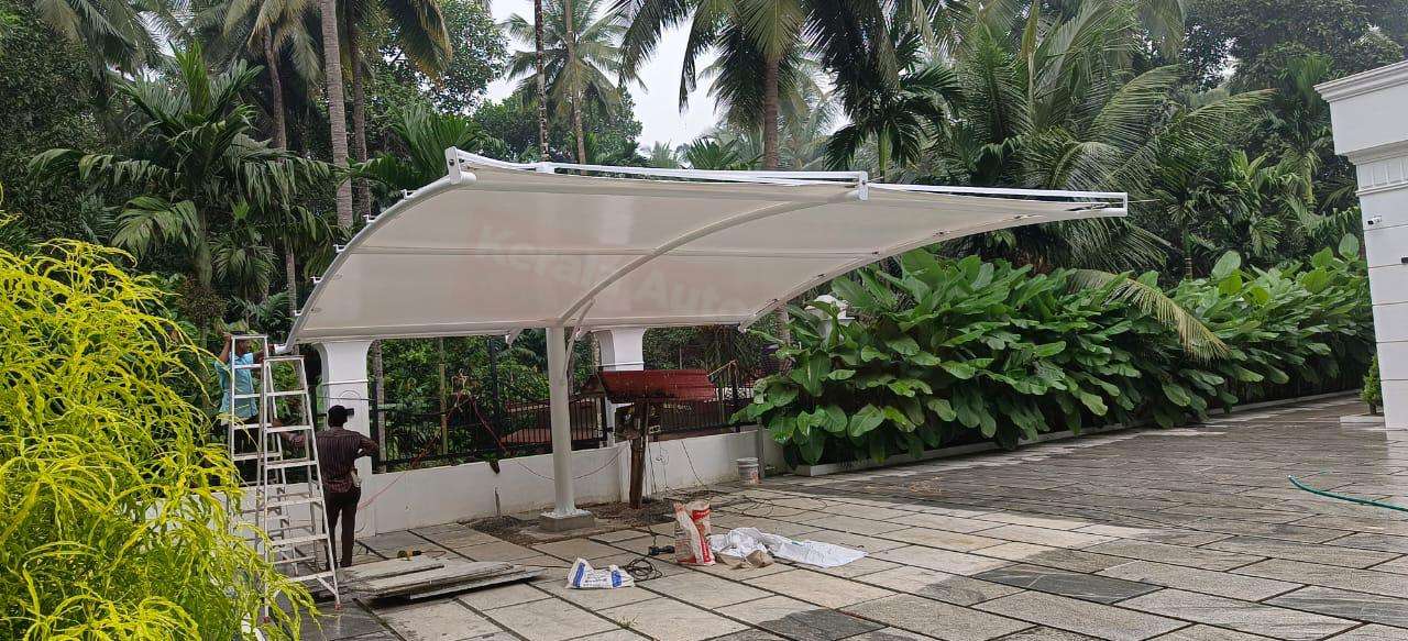 Modern tensile car porch design built in Adoor, Kerala using latest cantilever and roofing styles