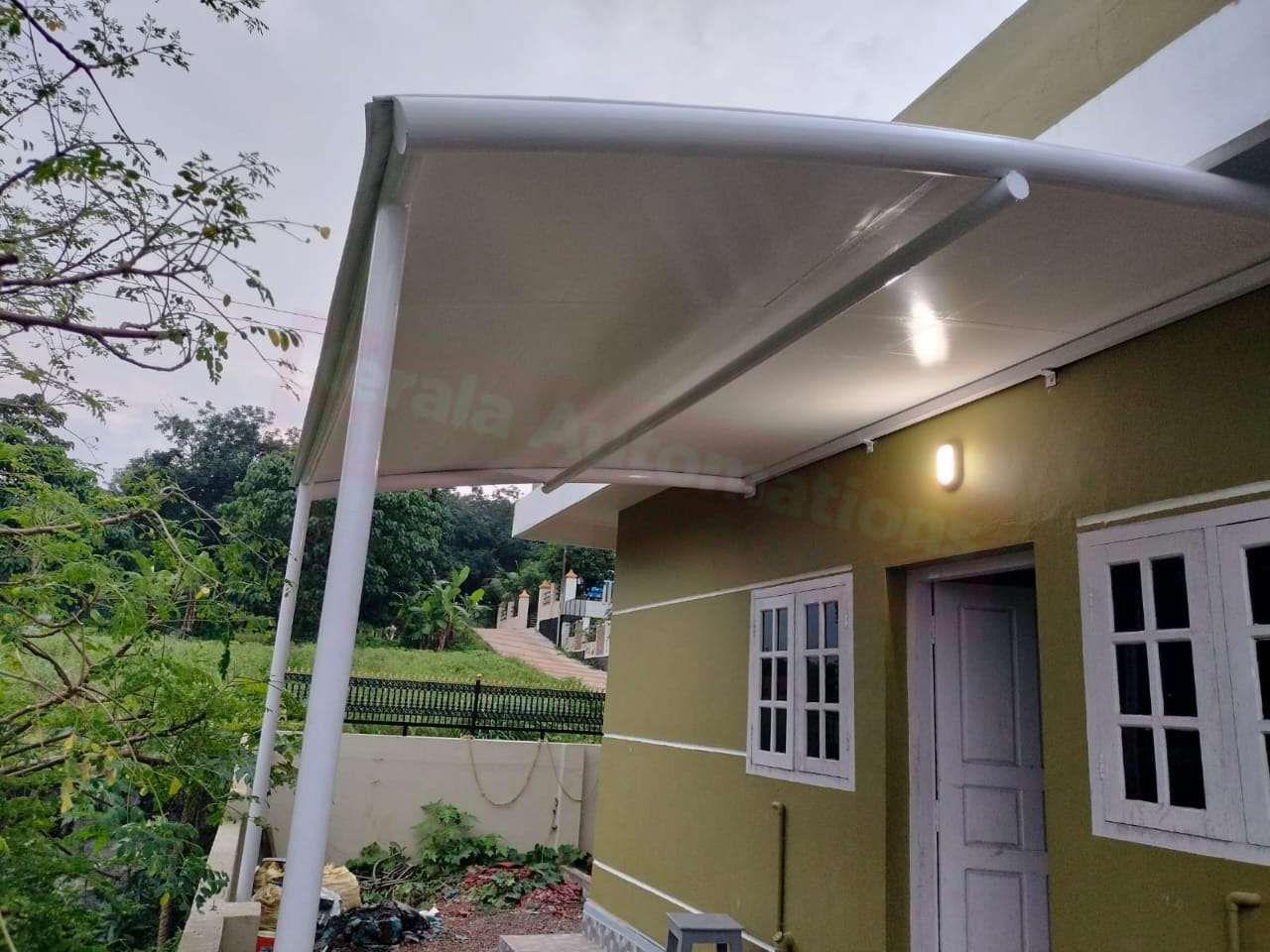 Modern tensile car porch design built in Changanassery, Kerala using latest cantilever and roofing styles