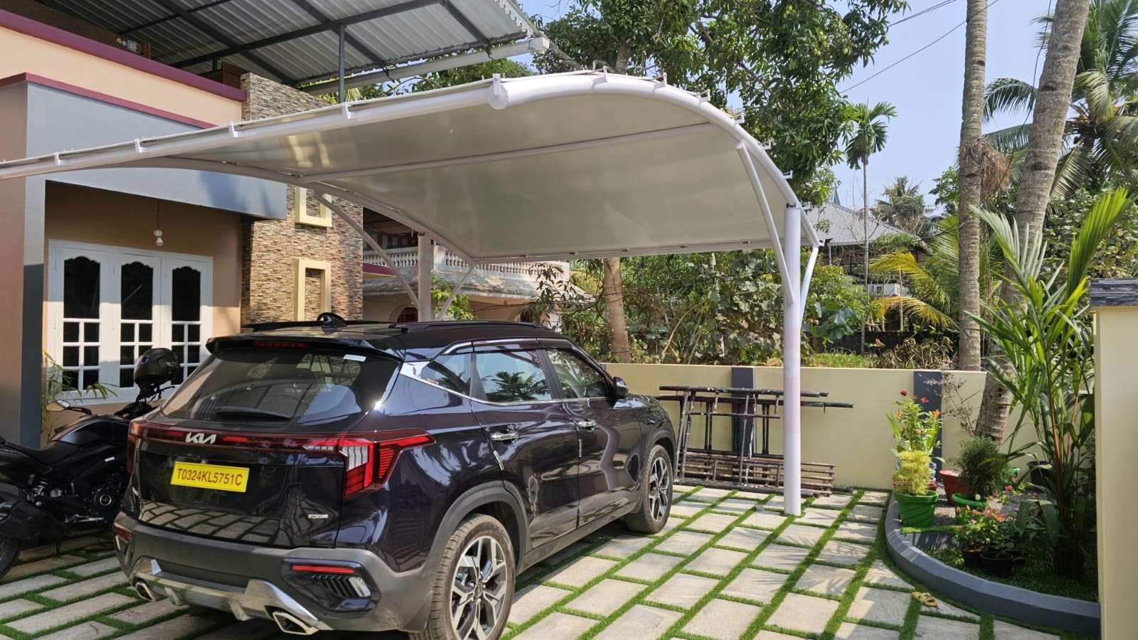 Modern tensile car porch design built in Kanjirappally, Kerala using latest cantilever and roofing styles