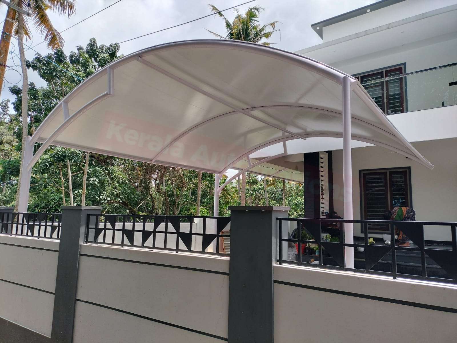 Modern tensile car porch design built in Kottarakkara, Kerala using latest cantilever and roofing styles