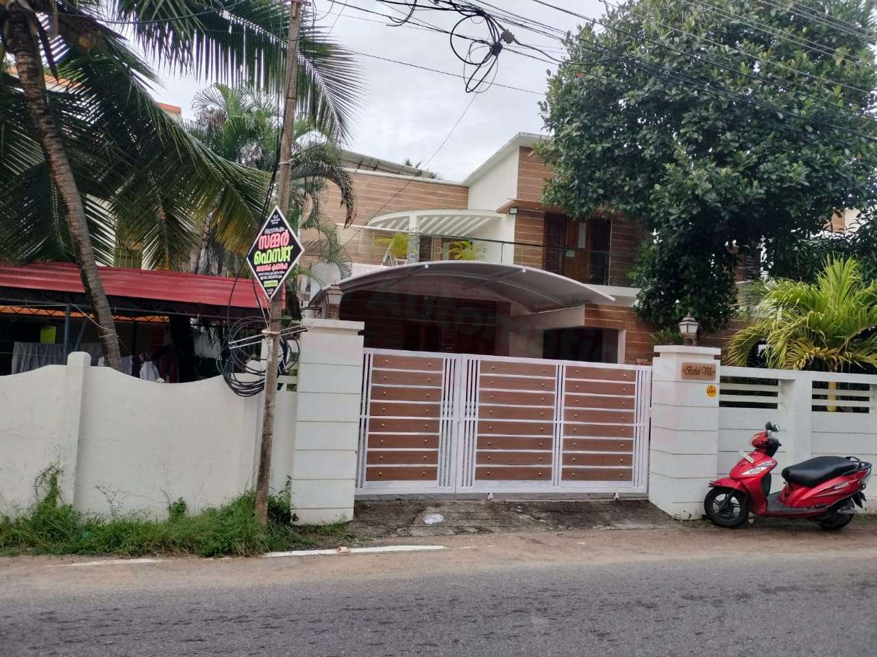 Modern tensile car porch design built in Kovalam, Kerala using latest cantilever and roofing styles