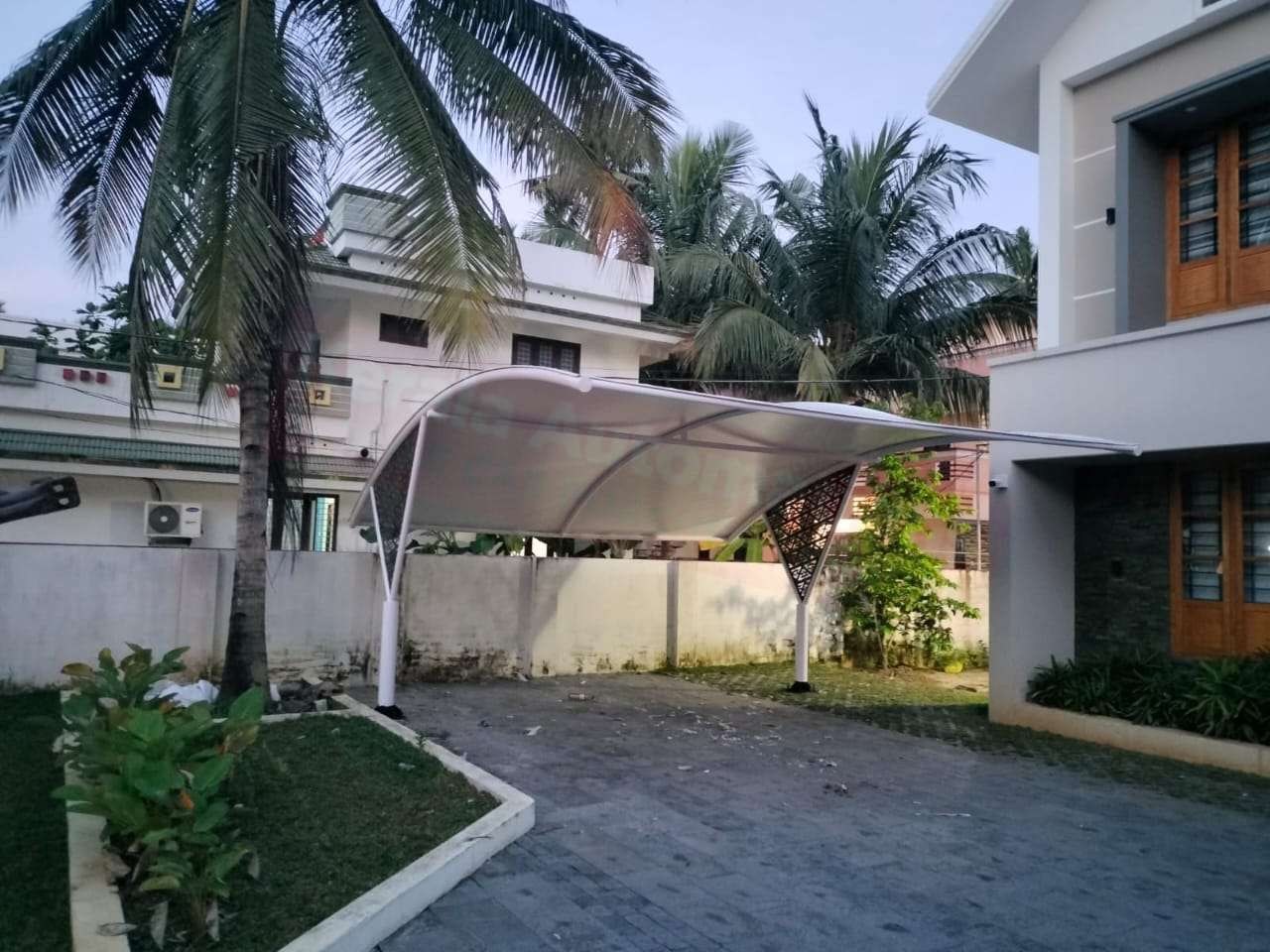 Modern tensile car porch design built in Kozhencherry, Kerala using latest cantilever and roofing styles