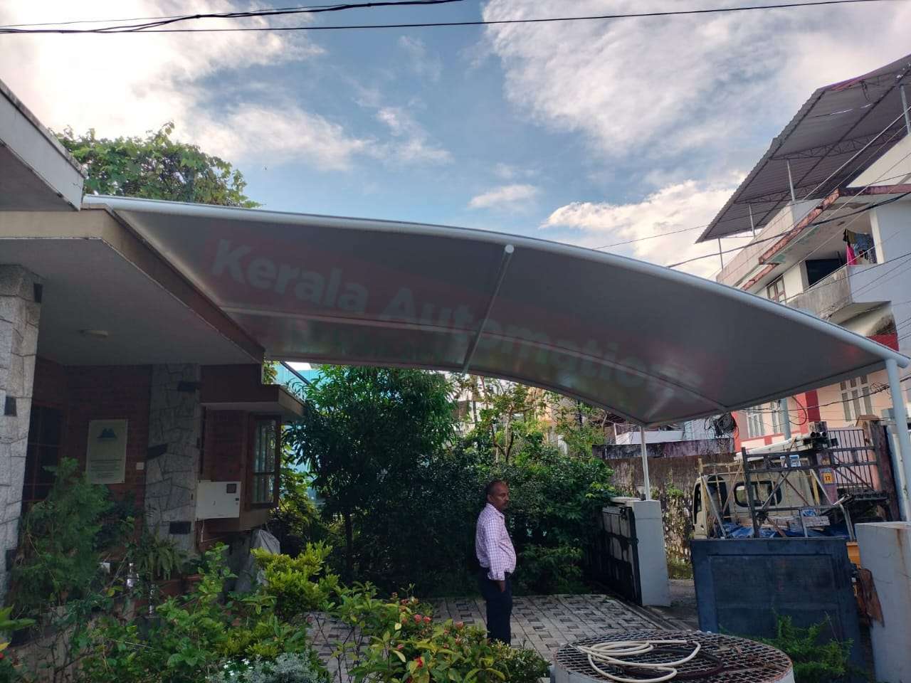Modern tensile car porch design built in Kundara, Kerala using latest cantilever and roofing styles