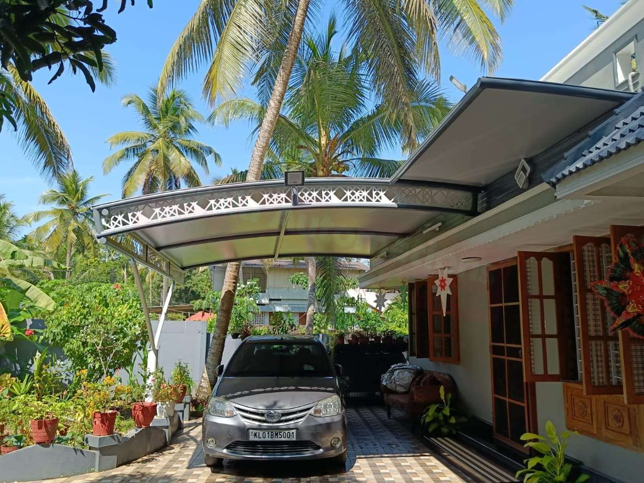 Modern tensile car porch design built in Pandalam, Kerala using latest cantilever and roofing styles